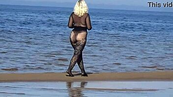 In a black style outfit she flashes confidently on the sunny beach enjoying the outdoor vibe. Nature surrounds her as she poses freely in heels and pantyhose.