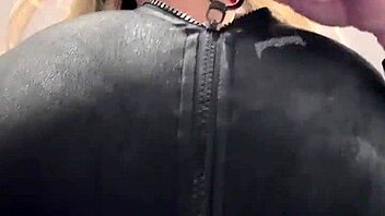 Big natural tits strain against the tight elastic leather material in a juicy display