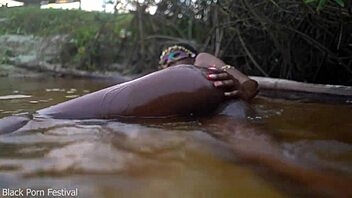 Skinny dark skinned African hottie contrasts teasing softness in the water