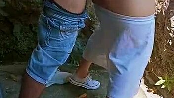 Excited couple enjoys outdoor fun behind abandoned house