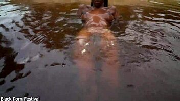 Skinny dark skinned African hottie contrasts teasing softness in the water