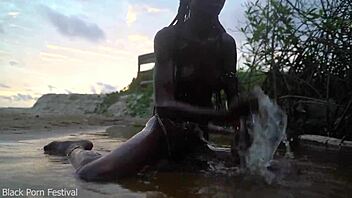 Skinny dark skinned African hottie contrasts teasing softness in the water