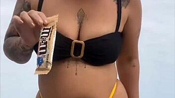 Wearing a tight yellow bikini that highlights her figure to draw attention at the beach