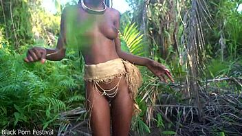 Hey, check out this perfect body dark skin African girl dancing half naked outdoors in raffia!