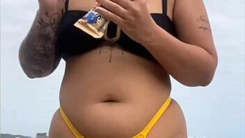 Wearing a tight yellow bikini that highlights her figure to draw attention at the beach