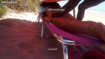 Ebony gives beach massage to curvy wife outdoors