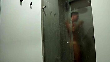 busty redhead surprises muscular guy in steamy shower