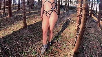 Forest path tease in sexy harness bondage hoping juicy pussy gets spotted outdoors