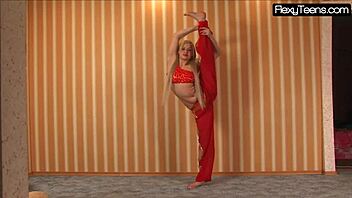 Sexy Russian blonde belly dancer stretches flexible body in red dress