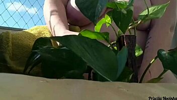 naked tattooed babe waters plants on balcony flashing tits