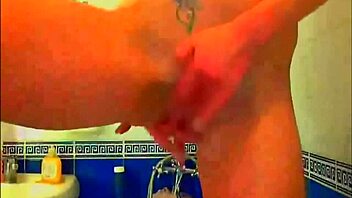 Tattooed model fingers pussy with glass dildo