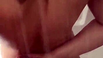 man cums on woman's big tits during shower blowjob session