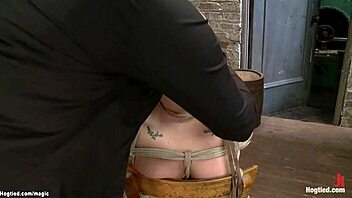 Busty brunette lezdom slave hogtied and punished on wooden chair in kinky bondage