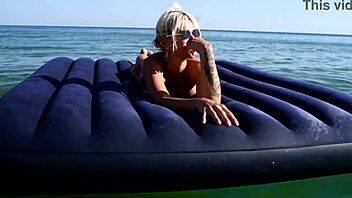 beautiful blonde big boobs nudist poses naked on beach with dolphins tattoo.