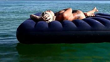 beautiful blonde big boobs nudist poses naked on beach with dolphins tattoo.