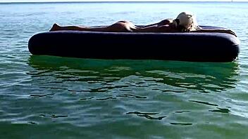 beautiful blonde big boobs nudist poses naked on beach with dolphins tattoo.