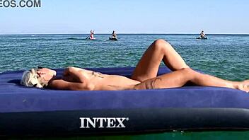 beautiful blonde big boobs nudist poses naked on beach with dolphins tattoo.