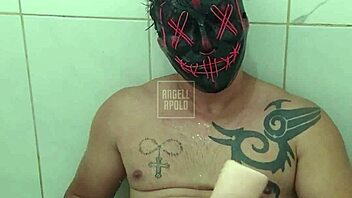 a masked tattooed man takes a shower alone and enjoys playing with his toy until he cums